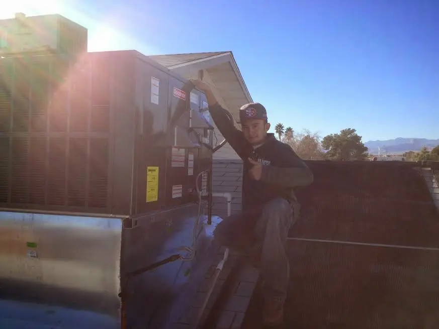 HVAC technician performing Air Duct Repair on a rooftop unit in Millcreek
